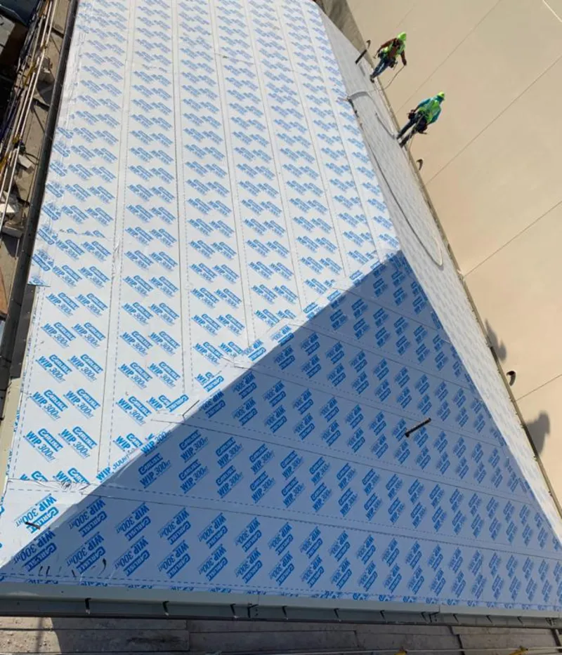 Professional roofers installing underlayment on a metal roof in Sheridan